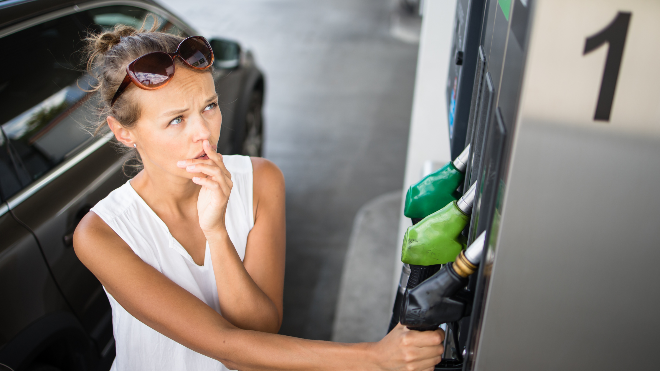 women looking at high prices at gas station
